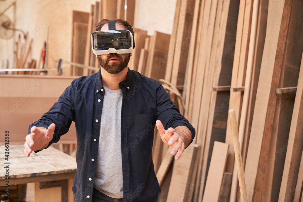 Craftsman with VR glasses in virtual reality workshop Craftsman with VR glasses in virtual reality workshop