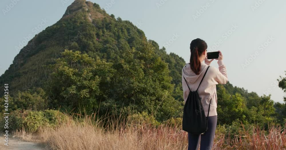 Woman go hiking on mountain and use of cellphone to take photo Woman go hiking on mountain and use of cellphone to take photo