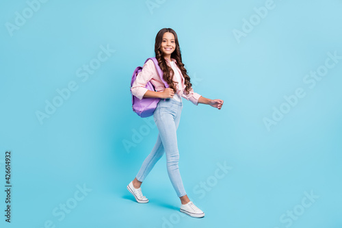 Full size photo of young happy smiling positive good mood girl wear backpack go to school isolated on blue color background