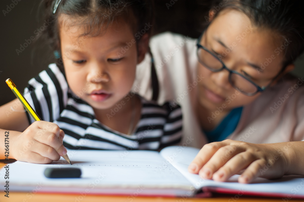 Happy family. Mother helps his little daughter do homework. Happy family. Mother helps his little daughter do homework.
