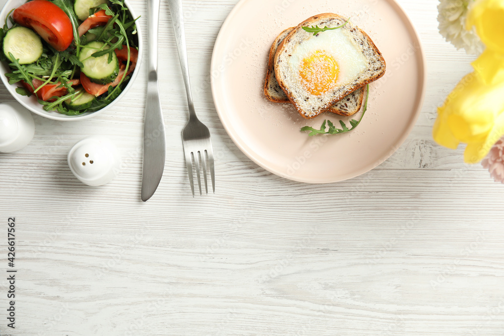 Delicious breakfast with fried egg, toasted bread and arugula served on white wooden table, flat lay. Space for text