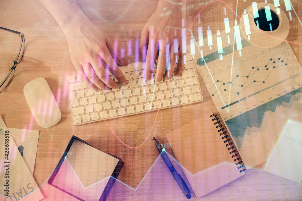 Multi exposure of man's hands typing over computer keyboard and forex graph hologram drawing. Top view. Financial markets concept.