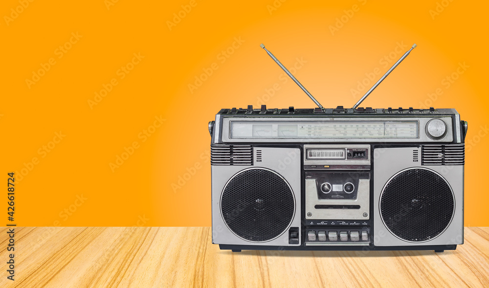 Obraz premium retro radio cassette recorder,old radio with old-fashioned tape player isolated on wooden floor texture and mint green gradient wall background.