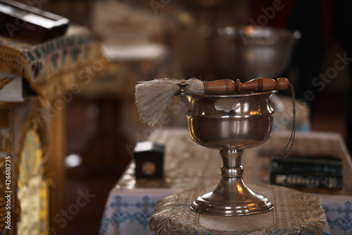 Silver vessel with holy water and brush on stand in church, space for text. Baptism ceremony photo