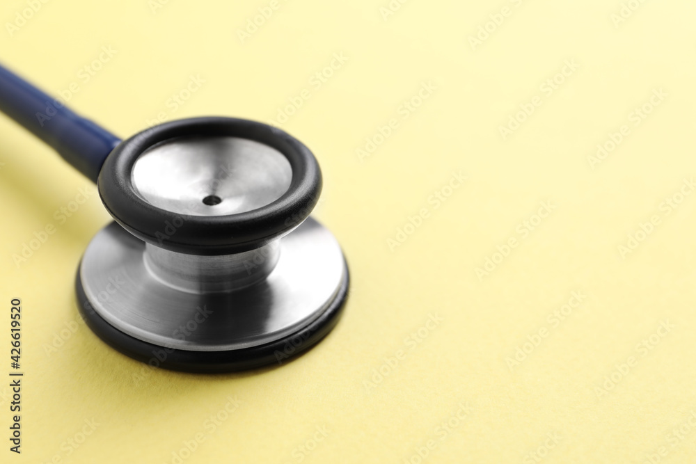 Stethoscope on yellow background, closeup. Space for text Stethoscope on yellow background, closeup. Space for text