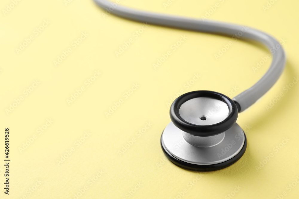 Stethoscope on yellow background, closeup. Space for text Stethoscope on yellow background, closeup. Space for text
