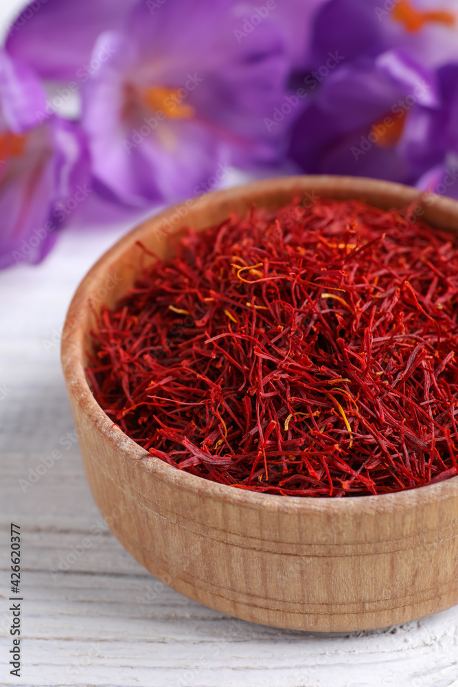 Fototapeta premium Dried saffron and crocus flowers on white wooden table, closeup