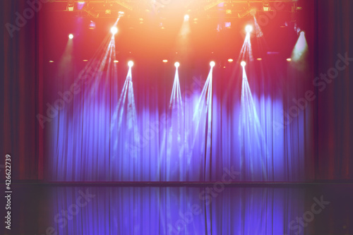 blurred empty theater stage with fun colourful spotlights, abstract image of concert lighting  illumination background