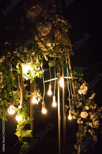 The close up of wedding ceremony with arch in rustic style with fresh flowers and macrame