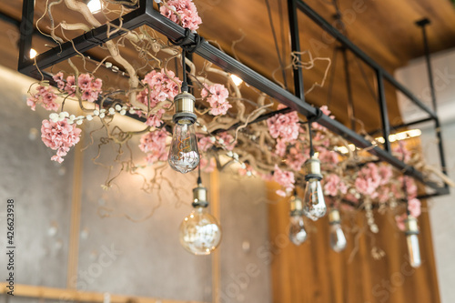 Fototapeta Naklejka Na Ścianę i Meble -  Decor with floral arrangement and Edison lamps
