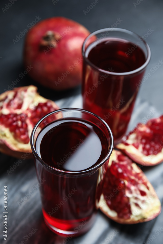 Pomegranate juice and fresh fruits on dark table Pomegranate juice and fresh fruits on dark table