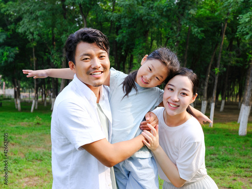 Happy family of three playing in the park