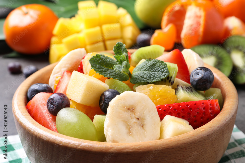 Delicious fresh fruit salad in bowl on table, closeup Delicious fresh fruit salad in bowl on table, closeup