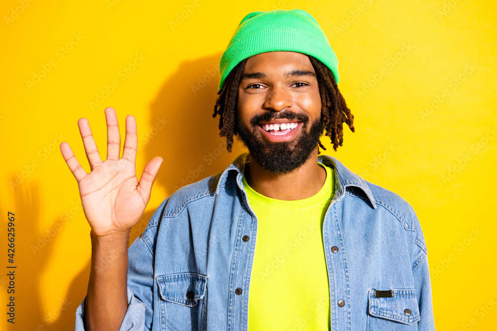 Photo of young handsome cheerful smiling good mood positive man showing hand greetings isolated on yellow color background Photo of young handsome cheerful smiling good mood positive man showing hand greetings isolated on yellow color background