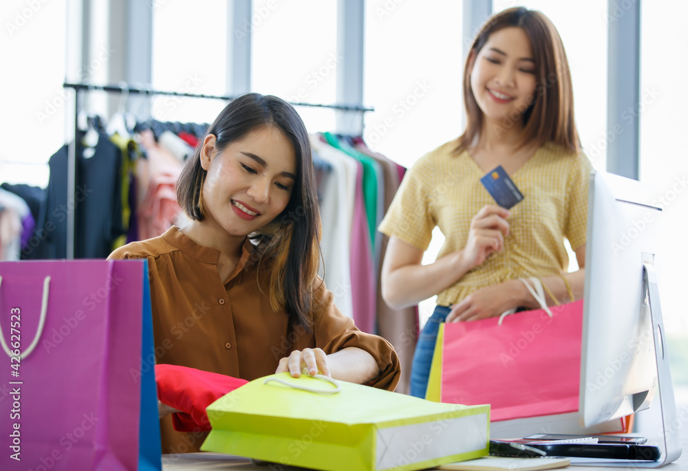 Asian saleswoman packing clothes for customer Asian saleswoman packing clothes for customer