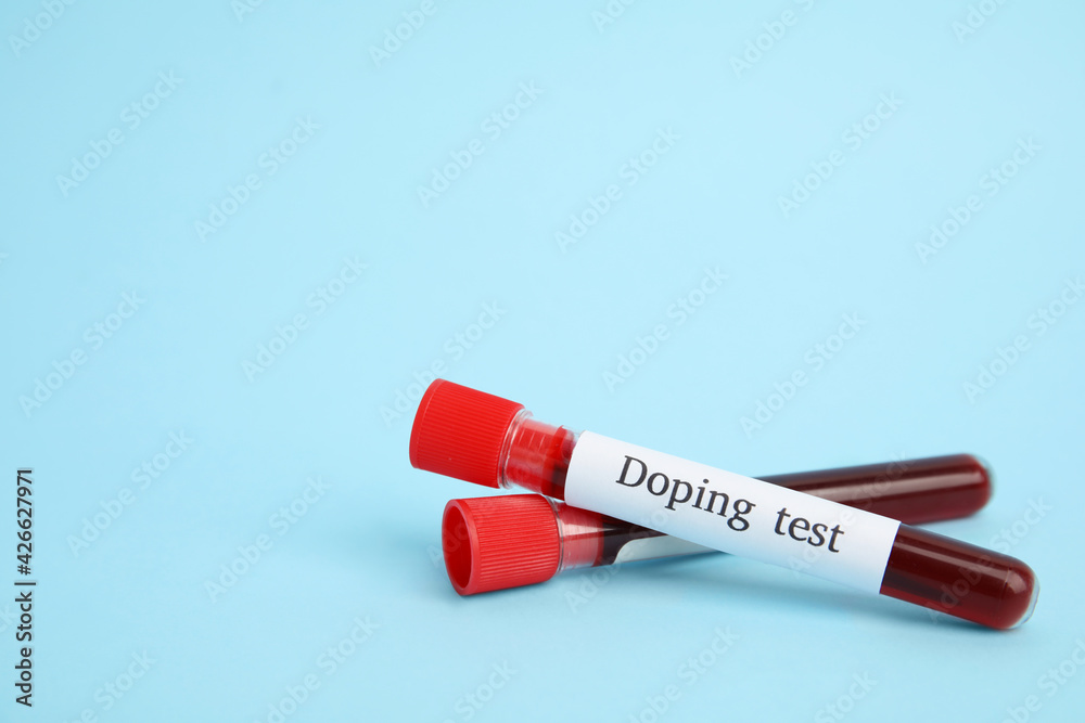 Test tubes with blood samples on light blue background, space for text. Doping control Test tubes with blood samples on light blue background, space for text. Doping control