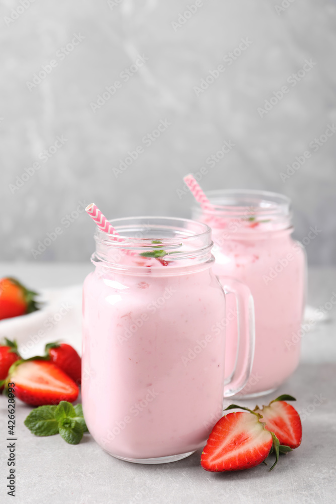 Delicious drink with strawberries on light table Delicious drink with strawberries on light table