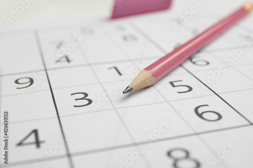 Sudoku puzzle grid and pencil, closeup view