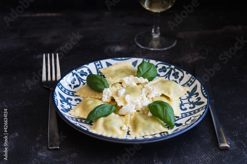 Cooked ravioli with ricotta and basil, on dark background 