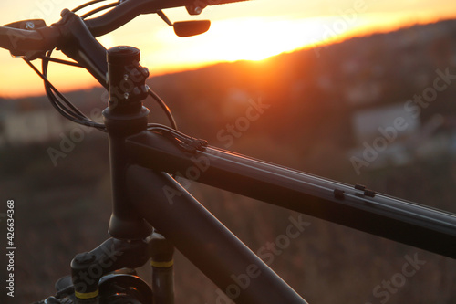 Bike on the background of the city and sunset on a sunny day