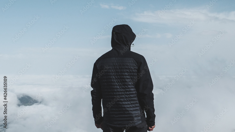 Silueta de hombre de espaldas con un mar de nubes de fondo. Stock Photo