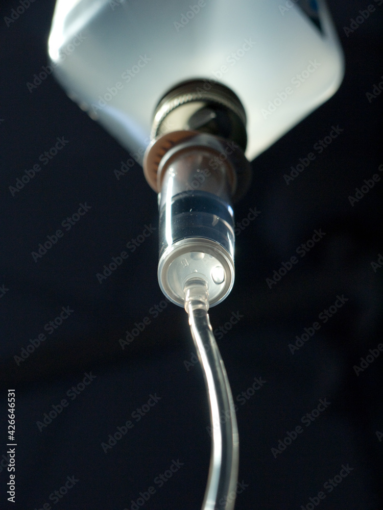 Infusion system in a plastic bottle, seen from below. Black background
