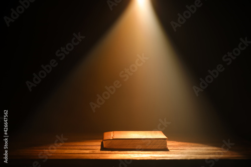 Old book on table against d...