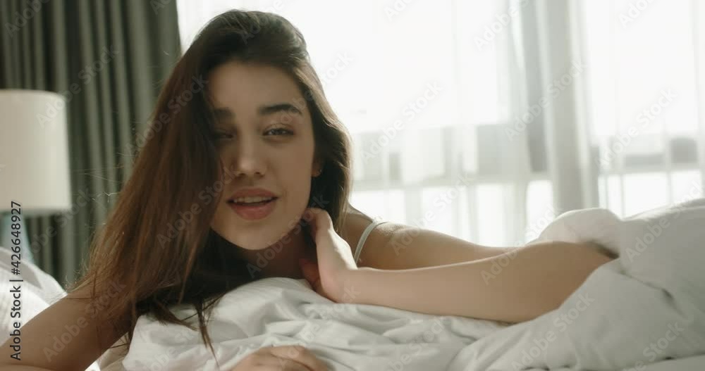 Cute asian gen z girl fooling around on cozy bed in morning, happily smiling and looking at camera, enjoying weekend and relaxing 4k footage Cute asian gen z girl fooling around on cozy bed in morning, happily smiling and looking at camera, enjoying weekend and relaxing 4k footage