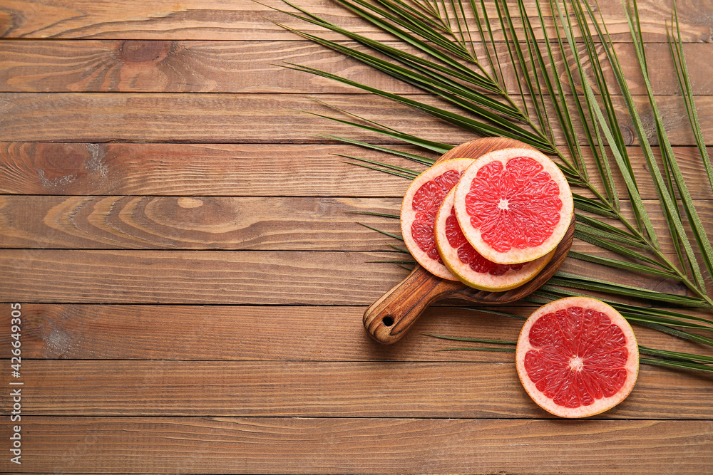 Fresh sliced grapefruit on wooden background