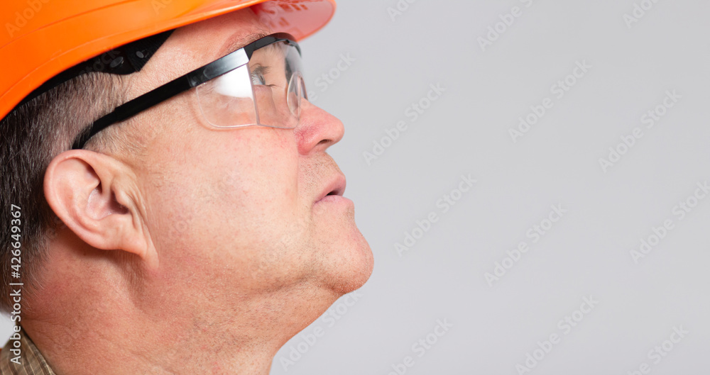 face profile of thoughtful plump engineer in protective glasses, construction worker in hard hat onstudio background face profile of thoughtful plump engineer in protective glasses, construction worker in hard hat onstudio background