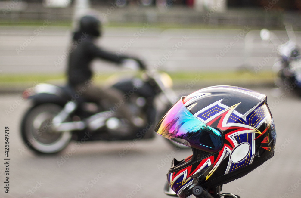 Bright motorcycle helmet in focus and out of focus motorcycle with motorcyclist