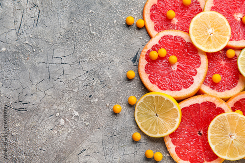 Fototapeta Naklejka Na Ścianę i Meble -  Vitamin C pills and citrus fruits slices on grey background