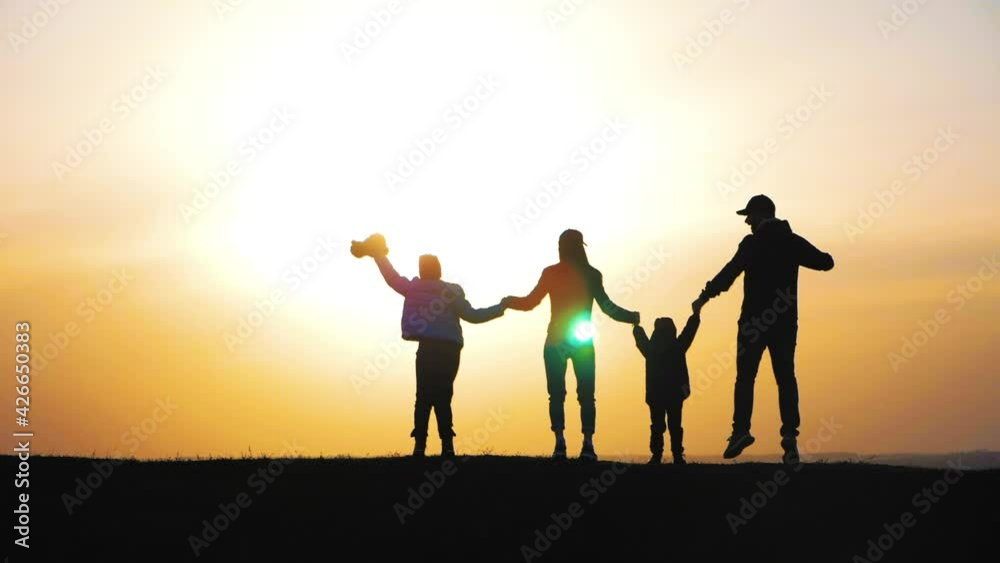 Teamwork. Family in the park. Happy family silhouette walk at sunset. Mom dad and children walk holding hands in the park. Silhouette family at sunset. Friendly family and teamwork kid dream concept. Teamwork. Family in the park. Happy family silhouette walk at sunset. Mom dad and children walk holding hands in the park. Silhouette family at sunset. Friendly family and teamwork kid dream concept.