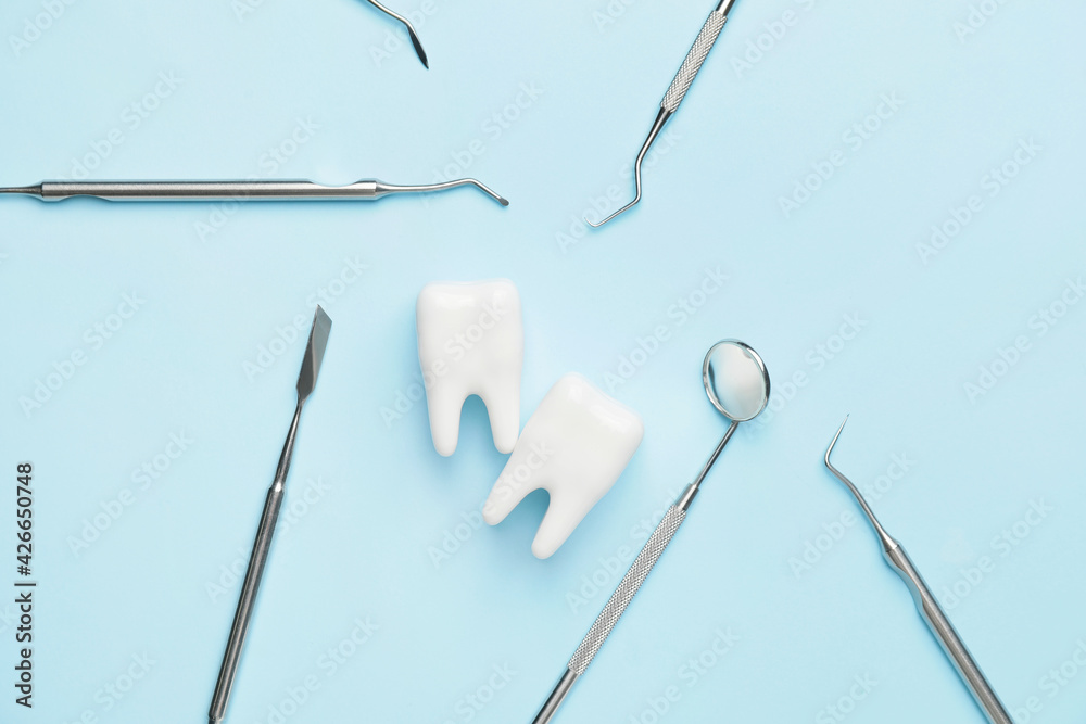 Dentist's tools and plastic teeth on color background Dentist's tools and plastic teeth on color background