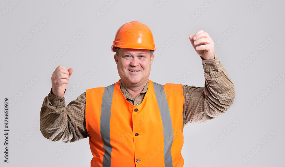 happy construction worker in hard hat with raised hand up on grey studio background, cheerful fat engineer happy construction worker in hard hat with raised hand up on grey studio background, cheerful fat engineer