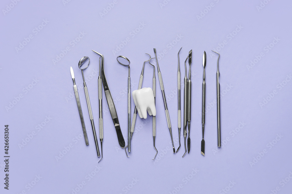 Dentist's tools and plastic tooth on color background Dentist's tools and plastic tooth on color background