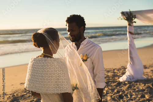 African american couple in love getting married on beach looking to each other