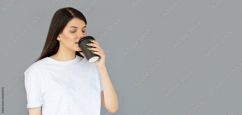 Portrait of a pretty woman drinking coffee cup isolated over gray background Portrait of a pretty woman drinking coffee cup isolated over gray background