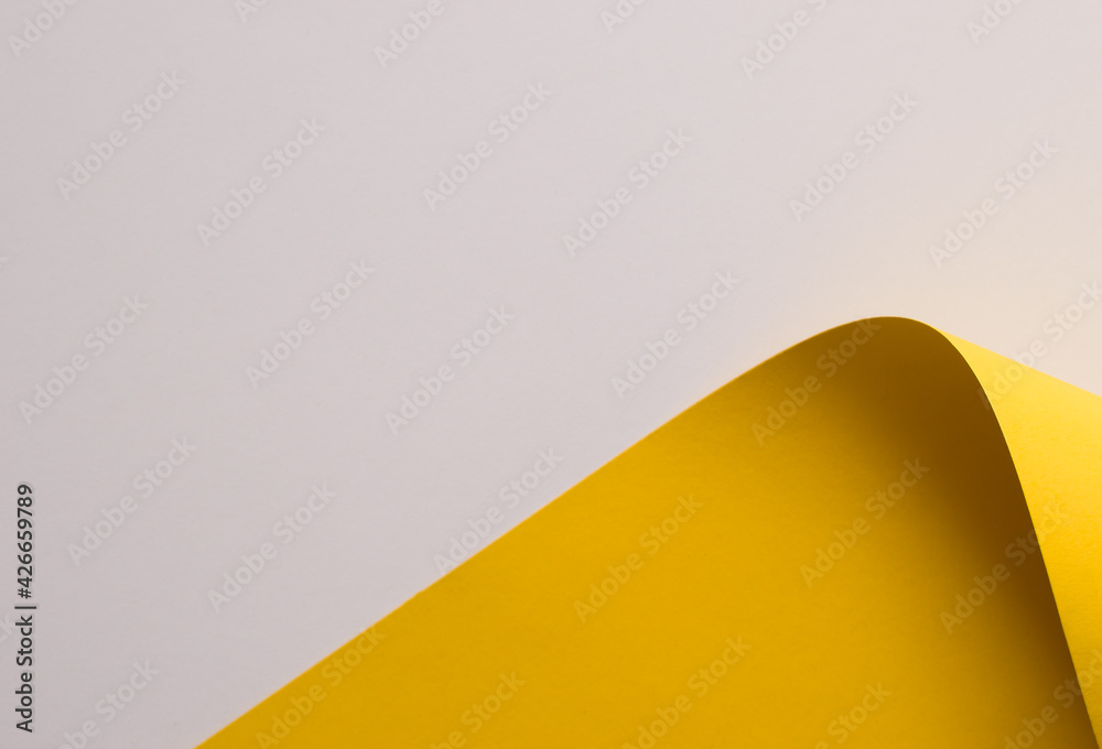 Folded yellow colored paper on white background, copy space Folded yellow colored paper on white background, copy space