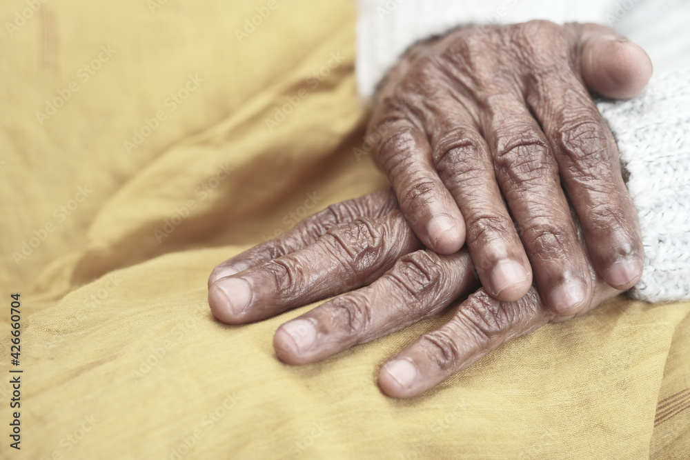 Fototapeta premium close up of hand of a elderly person on yellow 