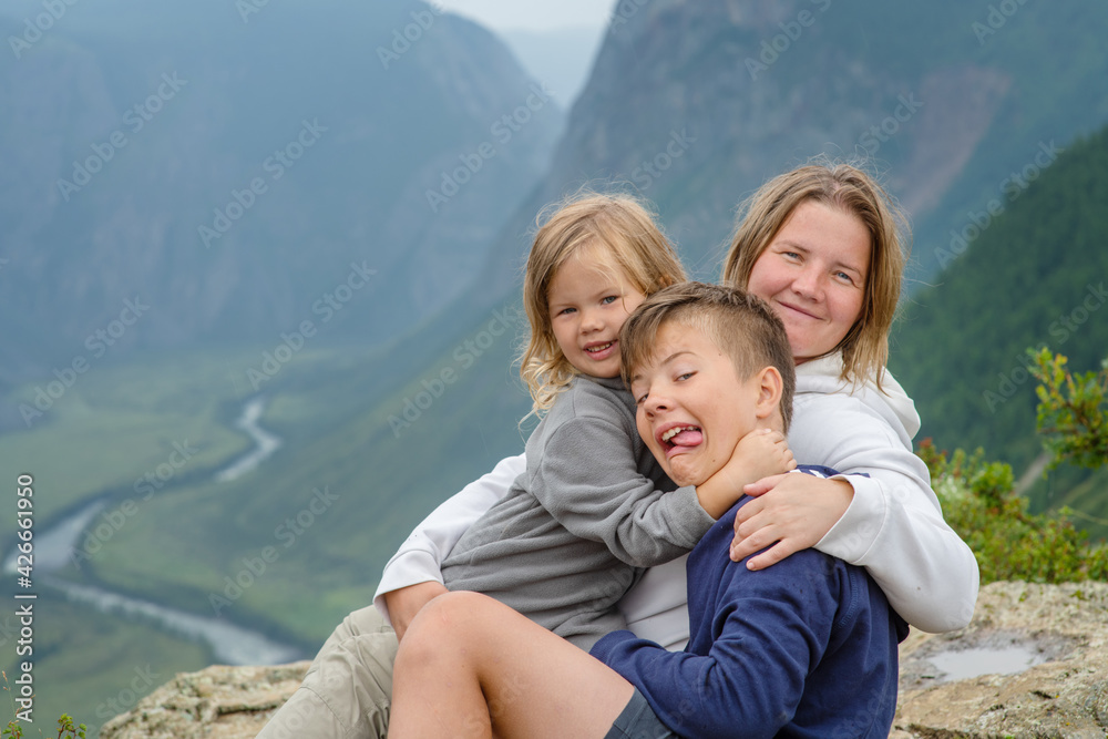 Friendly happy family against the background of the mountains and the valley of the chulyshman river in the mountains of the republic of altai Friendly happy family against the background of the mountains and the valley of the chulyshman river in the mountains of the republic of altai