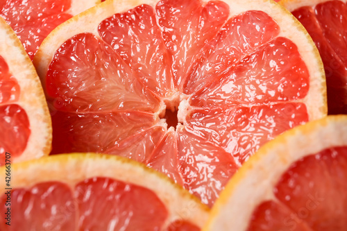 Slices of ripe grapefruits as background, closeup