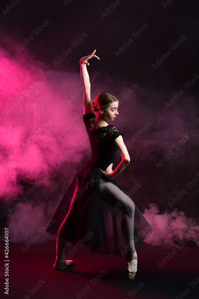 Beautiful young ballerina on dark color background