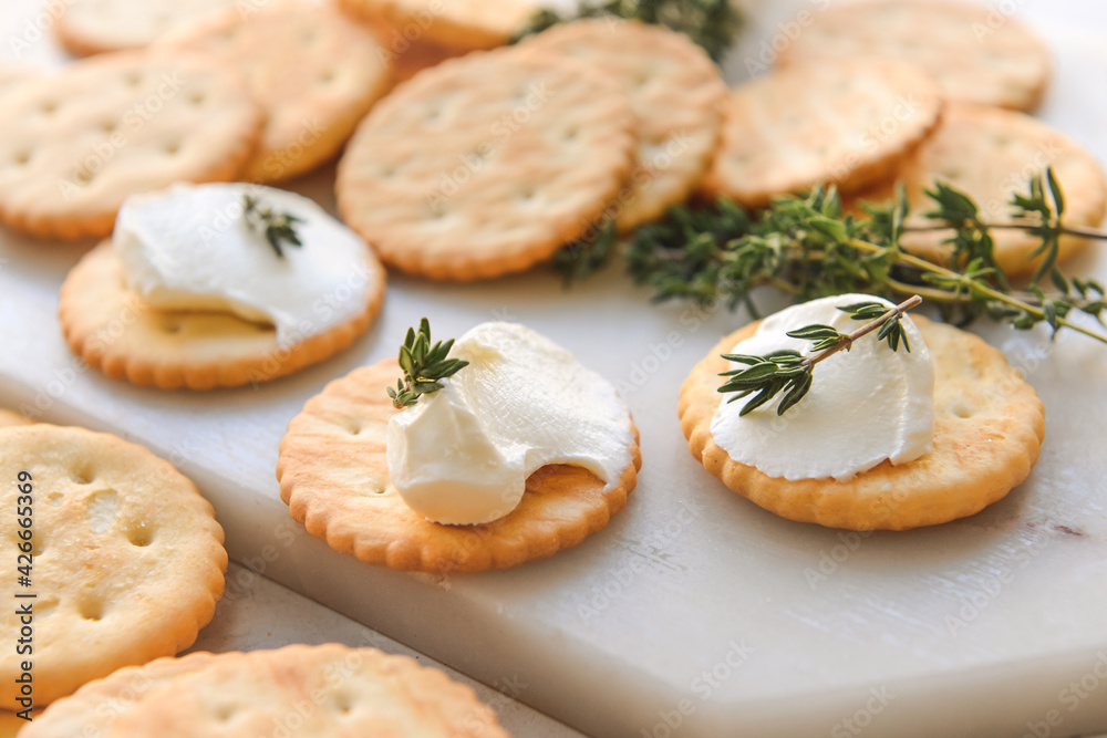 Crackers with cream on light background