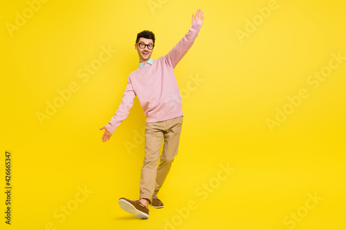 Full body photo of young excited man happy positive smile have fun dance isolated over yellow color background