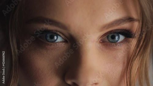 Young beautiful caucasian woman opens blue eyes close up macro human iris natural beauty