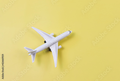  flatlay of airplane model on yellow background. Traveling or transportation concept.
