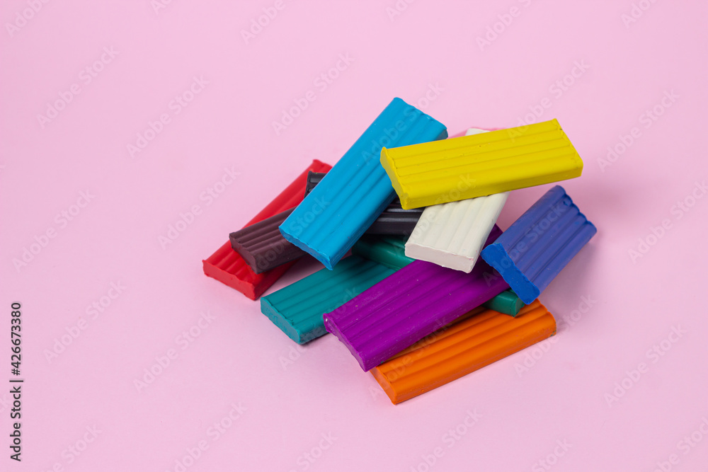 Multi-colored plasticine on a pink background. Educational game. Plasticine set Multi-colored plasticine on a pink background. Educational game. Plasticine set