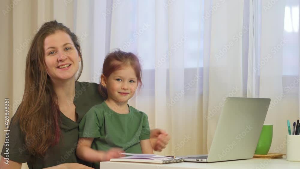 Mom and daughter at the laptop. A woman works from home with her child. Happy young woman and child talking on video chat, laughing, enjoying online conversation, Mom and daughter at the laptop. A woman works from home with her child. Happy young woman and child talking on video chat, laughing, enjoying online conversation,