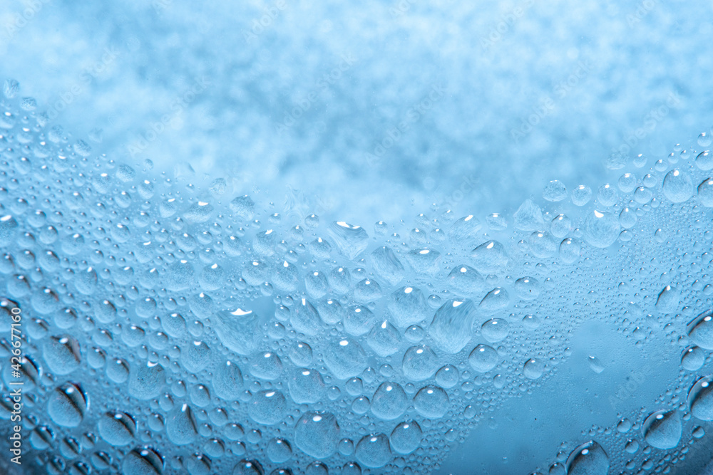 Obraz premium Blue background with water drops on glass